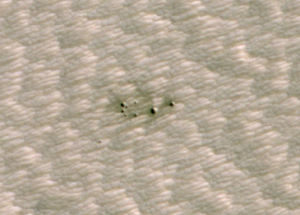 Imagem HiRISE da superfície de Marte mostrando um grupo de pequenas crateras confirmado após triagem por IA